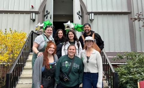 A group of UNE students poses in front of UNE's Ludcke Auditorium 